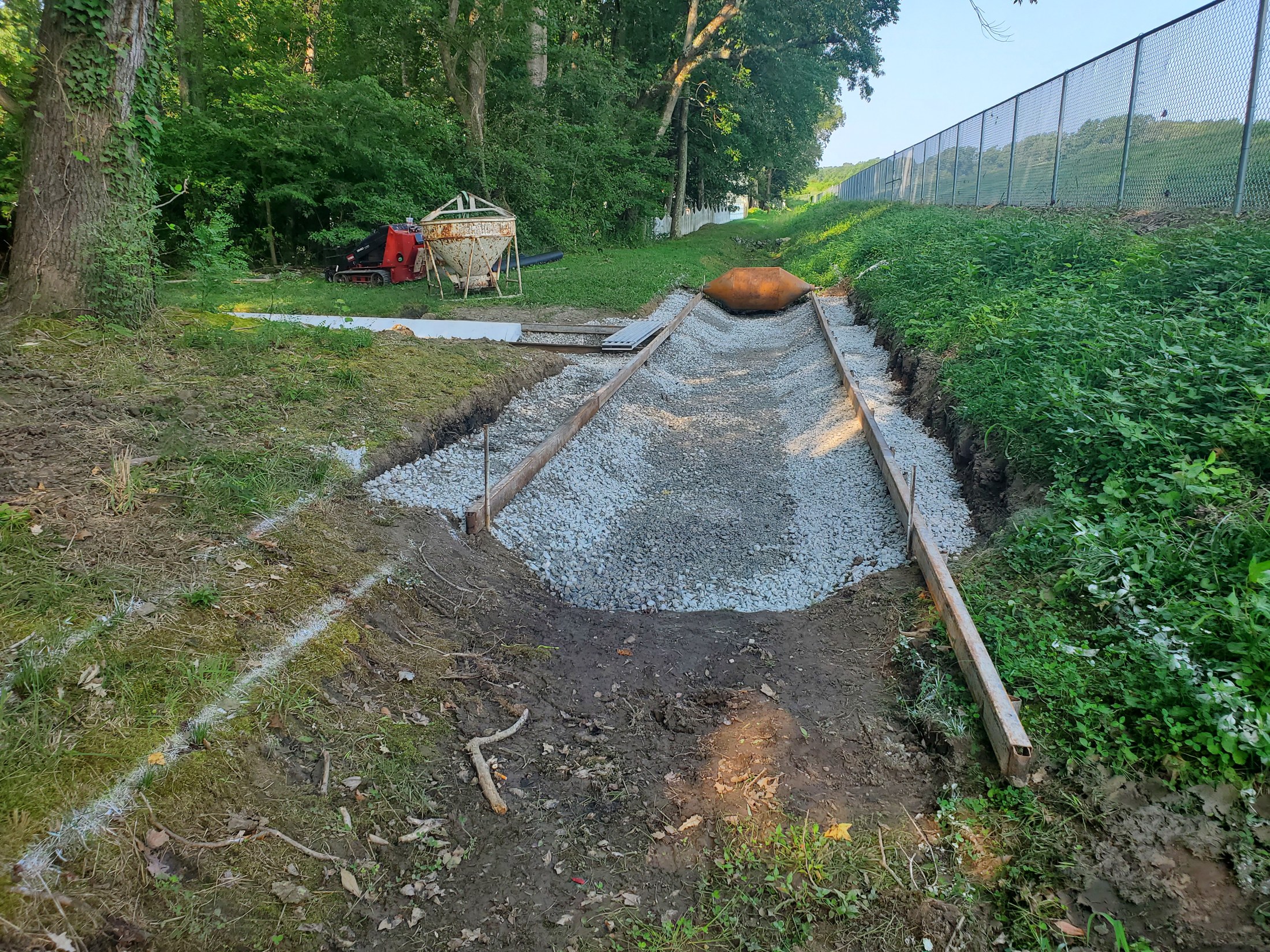 Stone base and forms establish the channel profile before concrete placement.