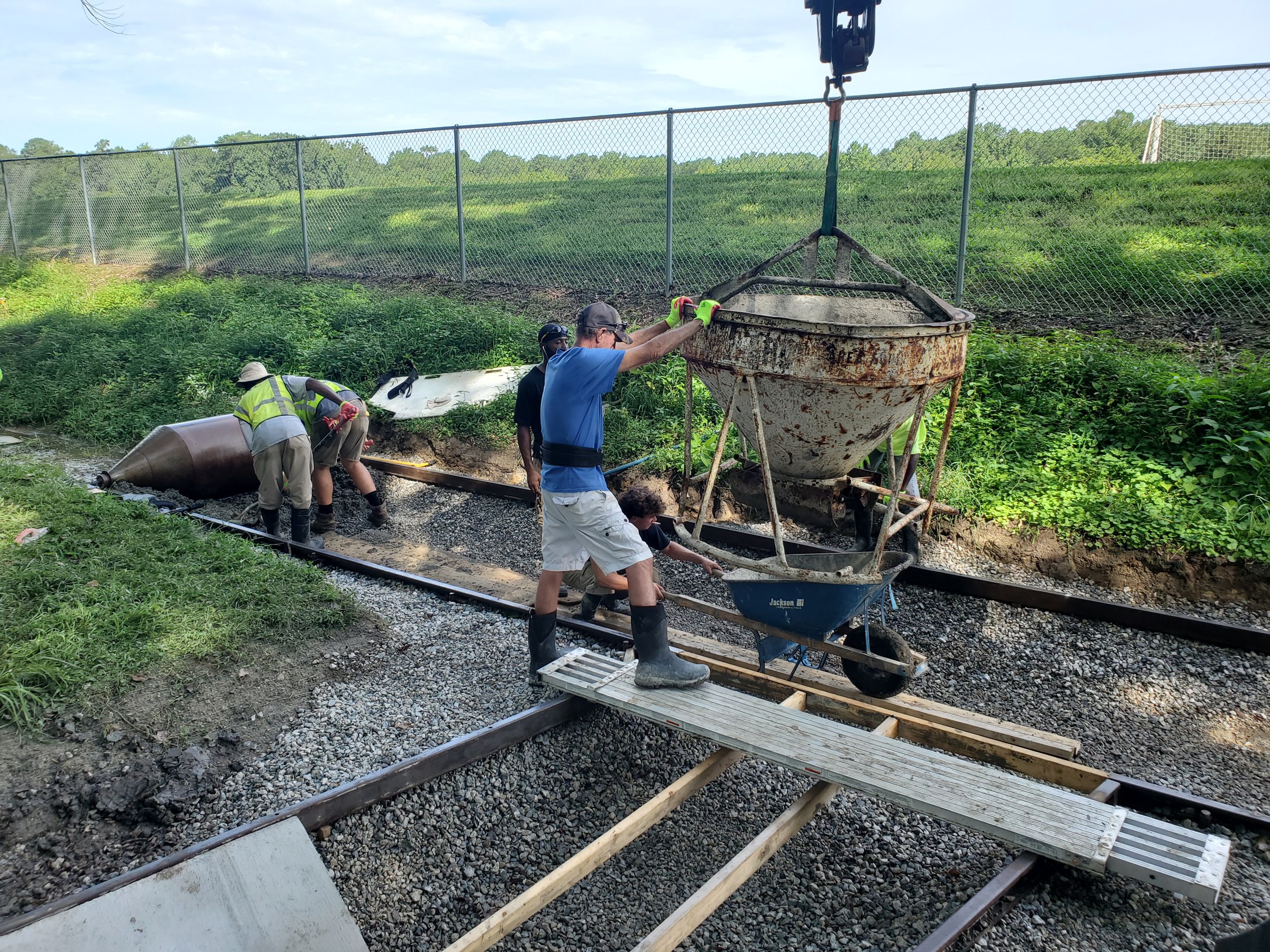 The crew places concrete along the prepared channel.