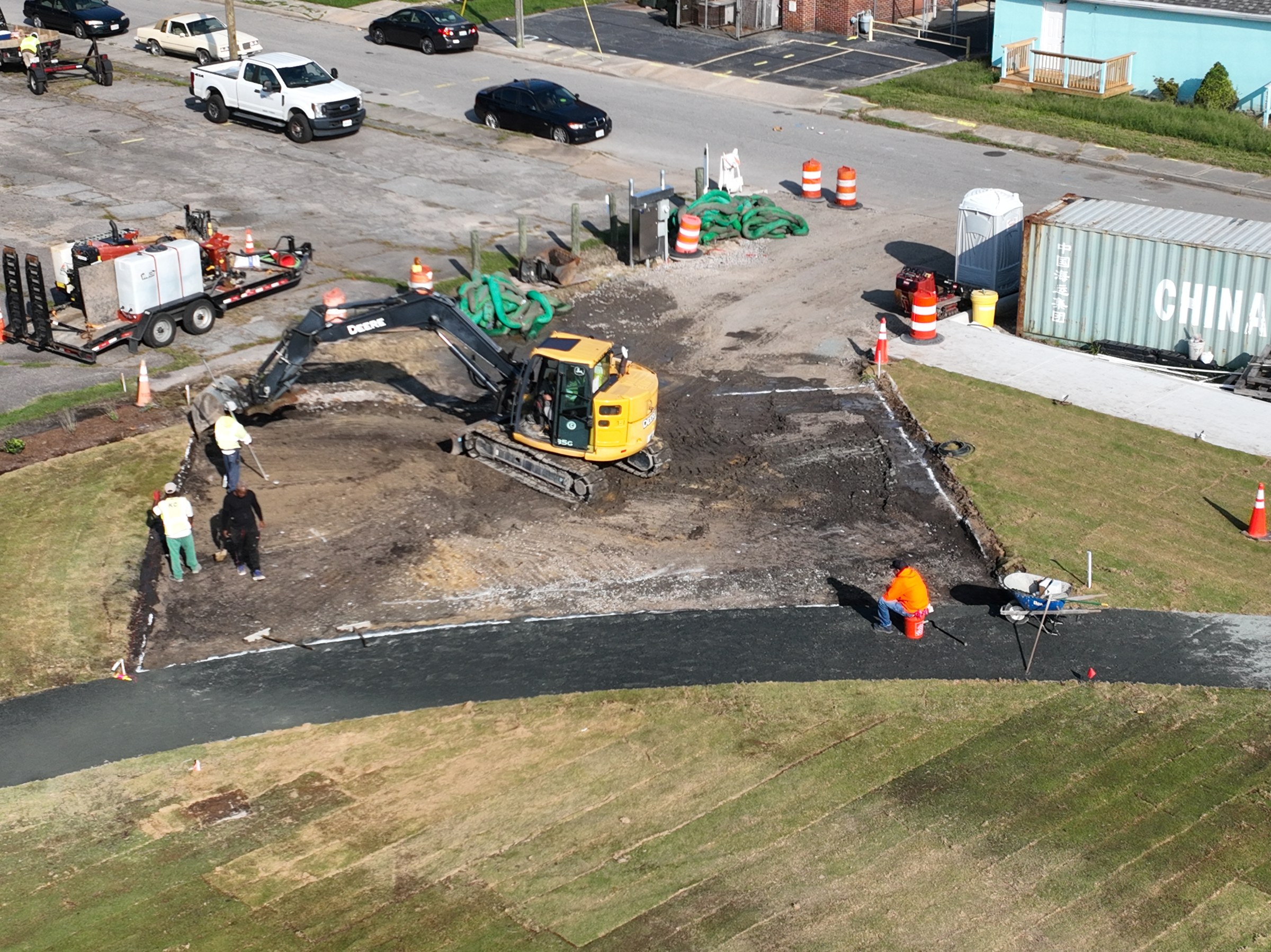 Equipment and crews work around the developing park and its existing street connections.