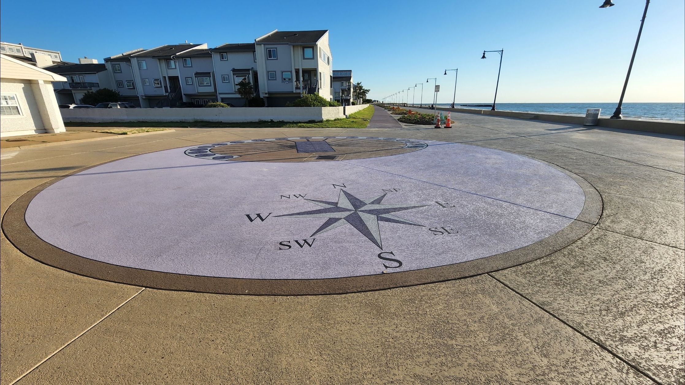 The human sundial and compass design integrated into the decorative boardwalk finish.